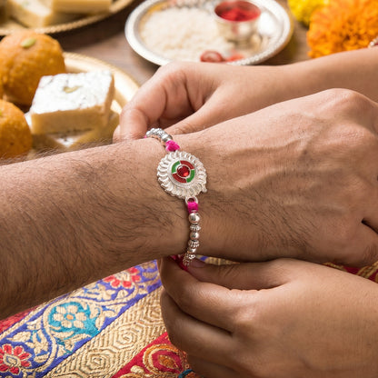 Silver Round Floral Rakhi with Red Stone and Pink Beads