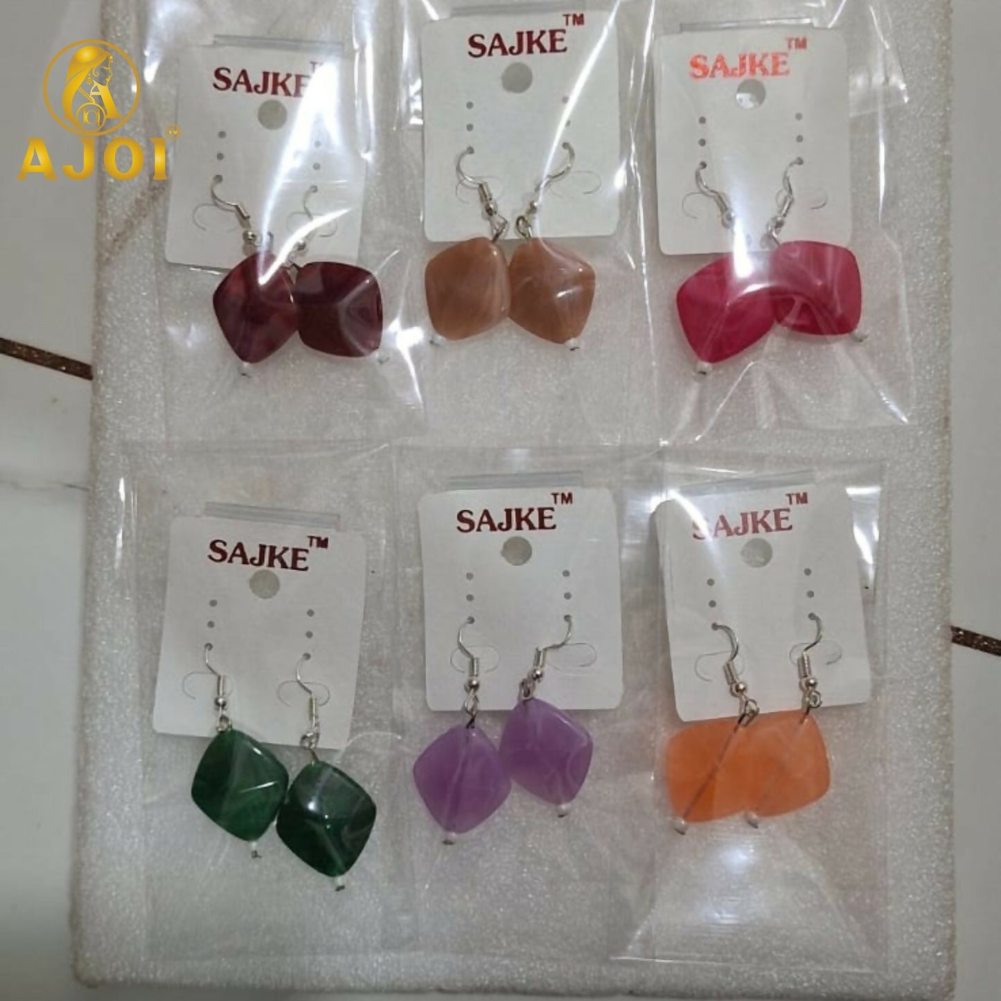 Deep red stone geometric drop earrings on display