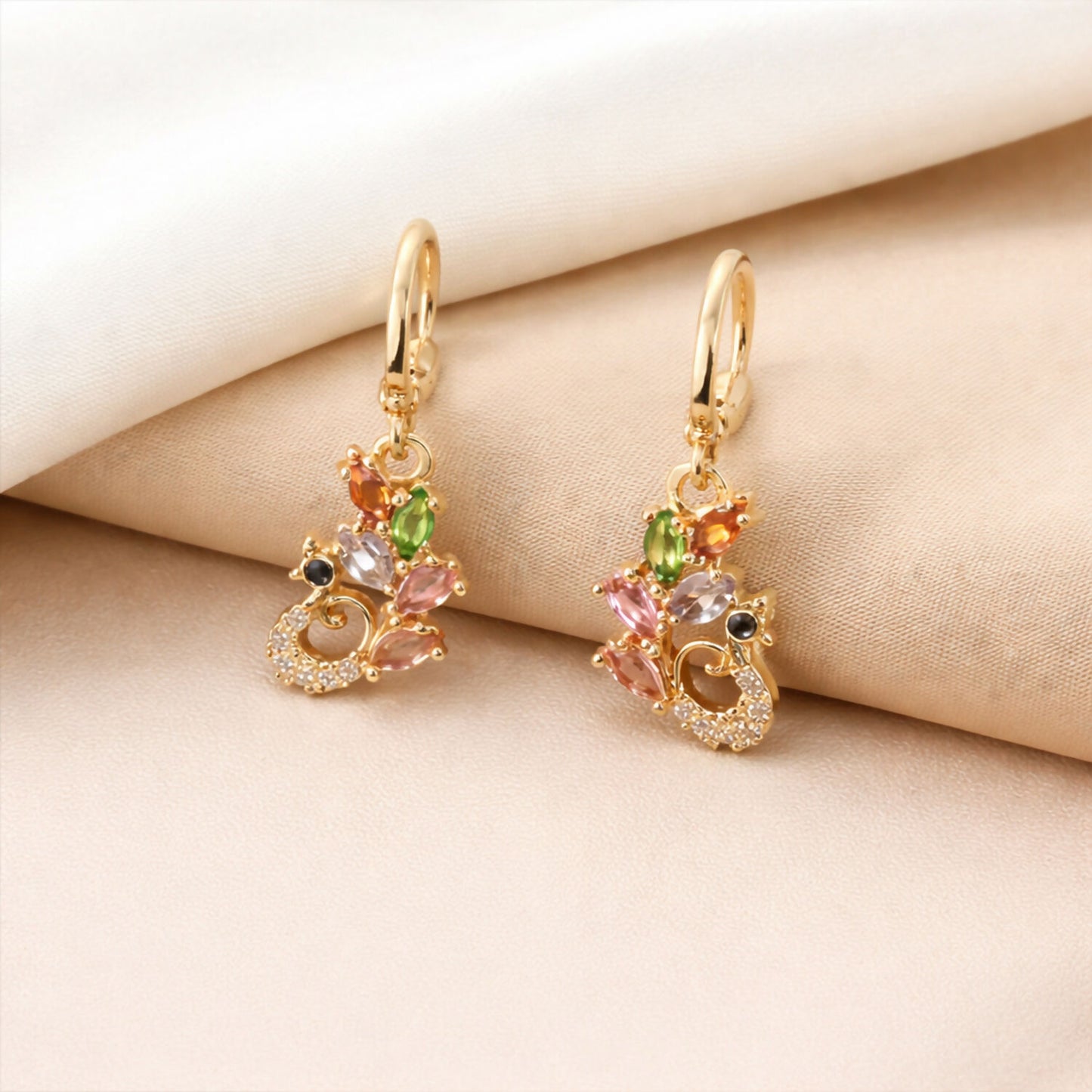 Elegant gold finish earrings featuring green, amber, blush pink, and clear gemstones