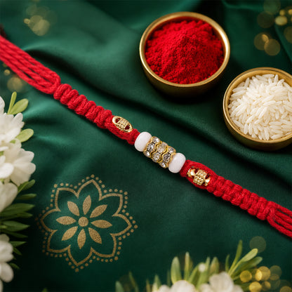 Red Braided Rakhi with White Beads and Antique Gold Accent Charms