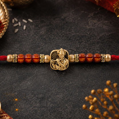 Red Beaded Rakhi with Antique Gold Krishna Charm and Wooden Beads