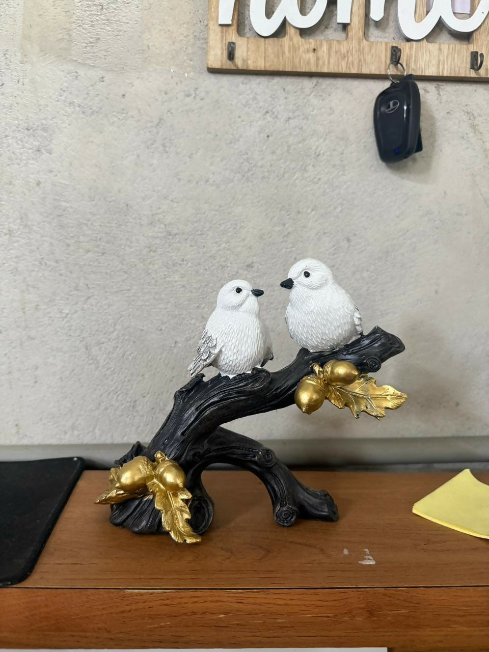 Elegant bird couple showpiece with golden leaves in natural light