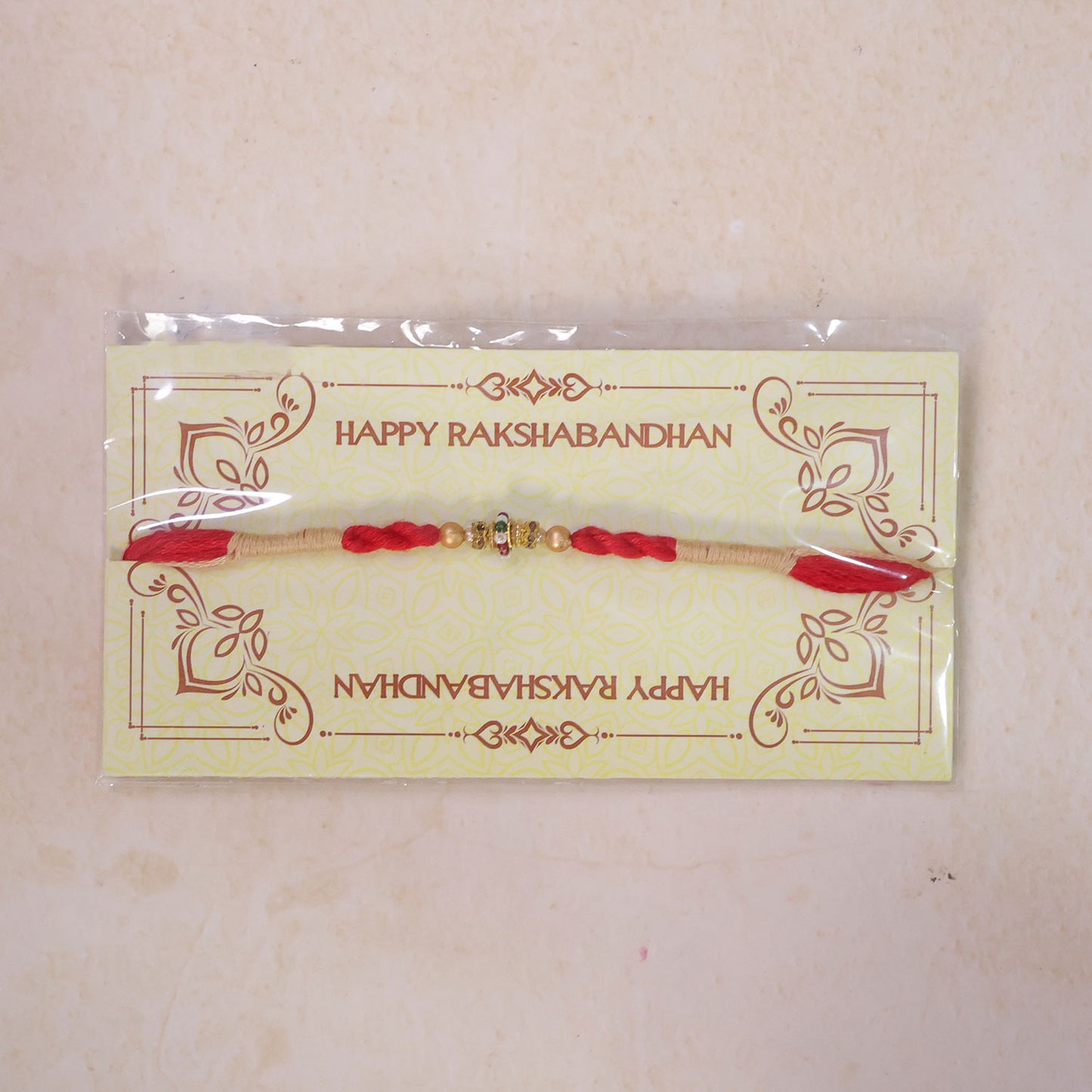 Red Twisted Cord Rakhi with a Colourful Enamel Bead and Gold Accents