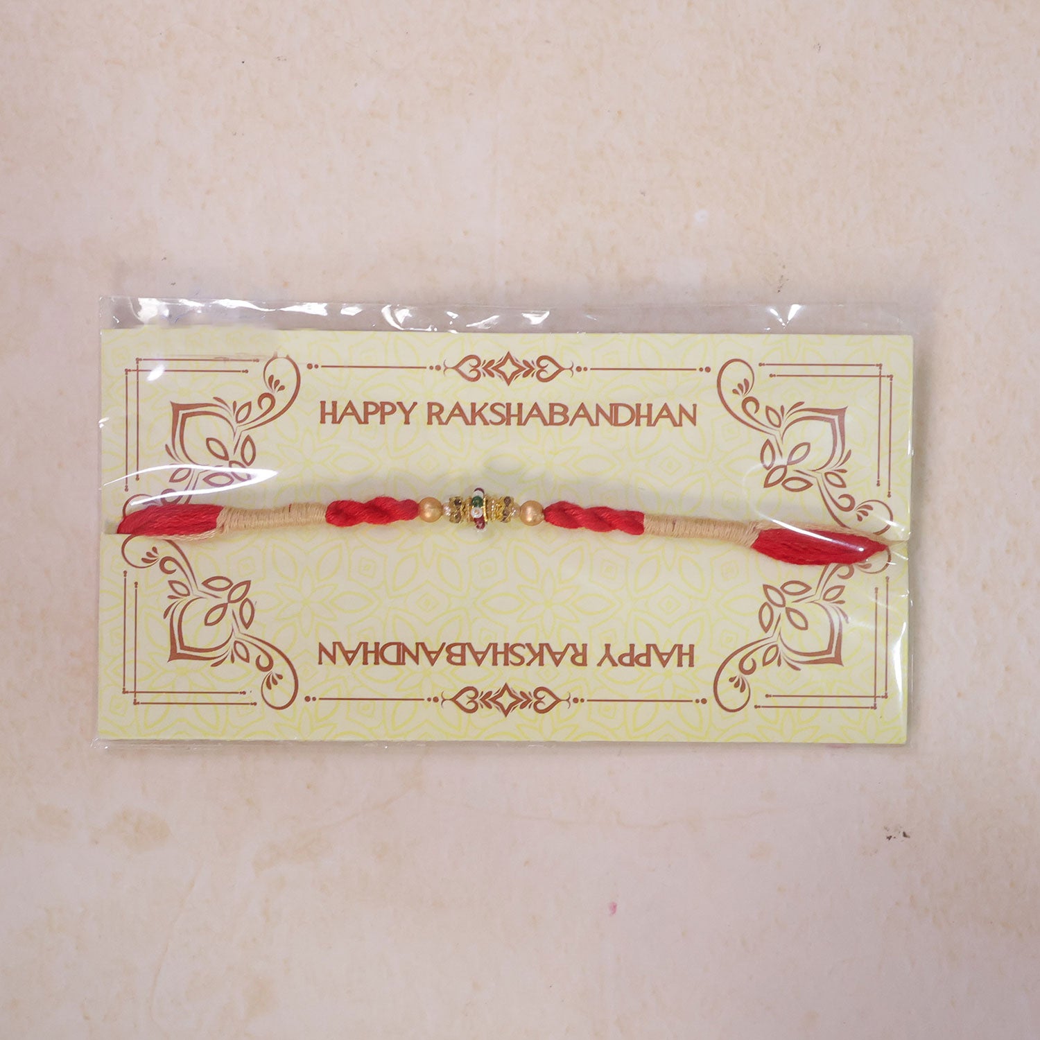 Red Twisted Cord Rakhi with a Colourful Enamel Bead and Gold Accents