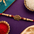 Red Thread Rakhi with Antique Gold Radhe Pendant and Peacock Feather