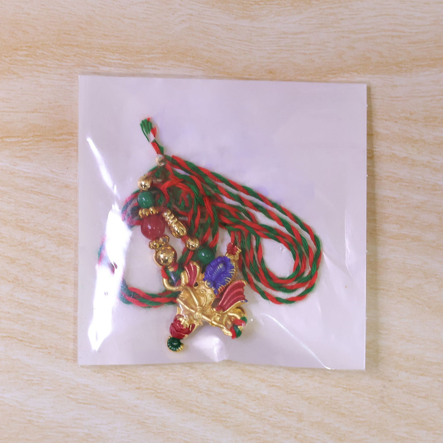 Lord Krishna Flute Pendant Rakhi with Red and Green Beads