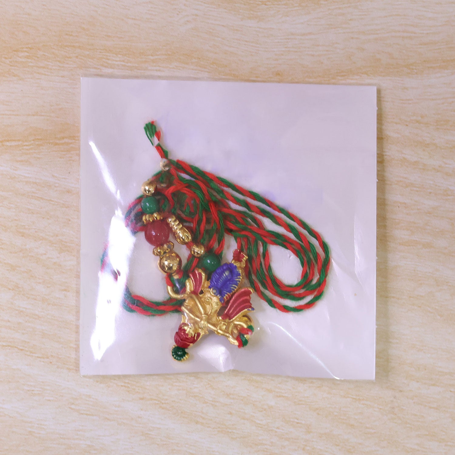 Lord Krishna Flute Pendant Rakhi with Red and Green Beads
