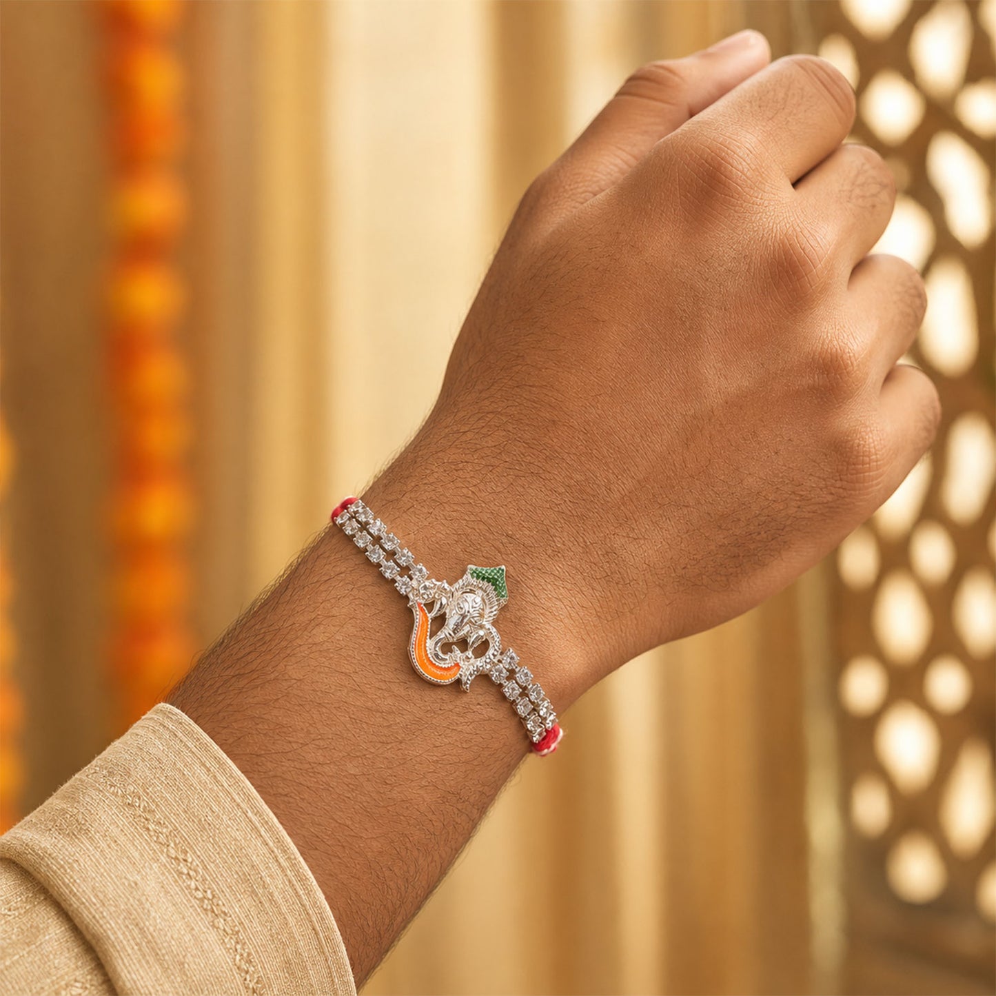 Traditional Rakhi showcasing Ganesha Charm, red stone accents and gift look for Gift