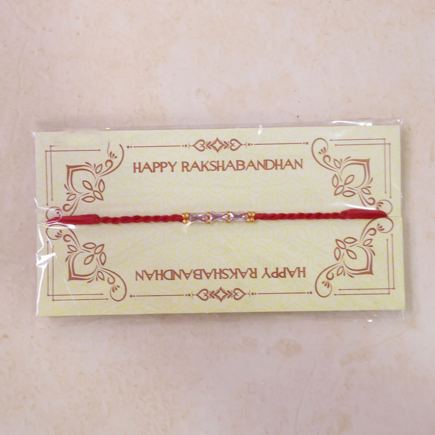 Red Thread Rakhi with a Row of Pink Baguette-Cut Crystal Beads