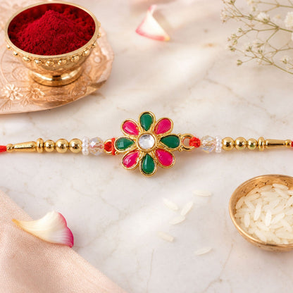 Radiant Floral Rakhi Adorned with Pink-Green Stones, Pearls and Gold-Tone Beads (5pcs)