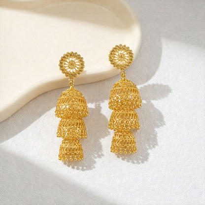Dome-shaped layered jhumka earrings with bead accents in gold tone