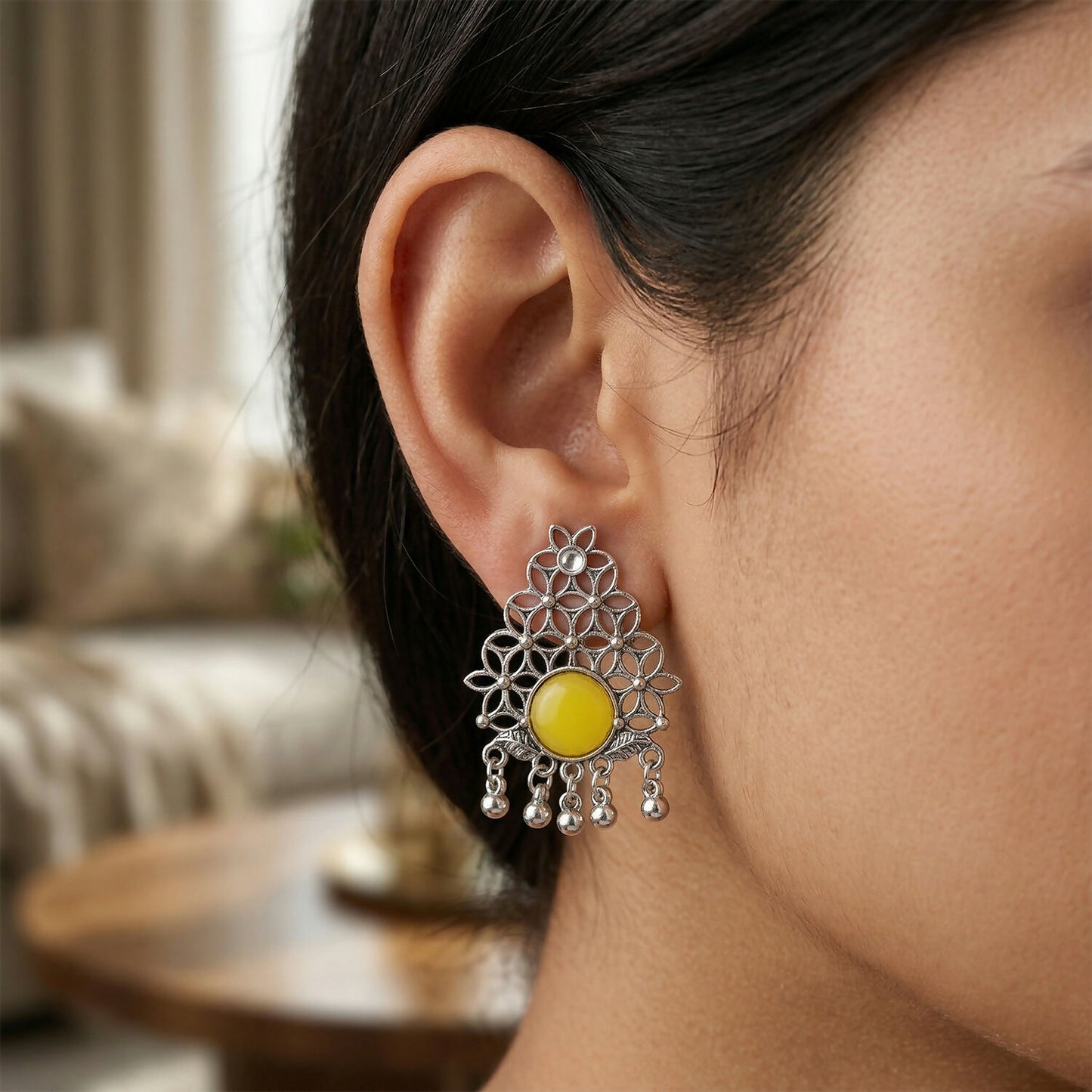 Side view of oxidized silver filigree earrings with yellow stone