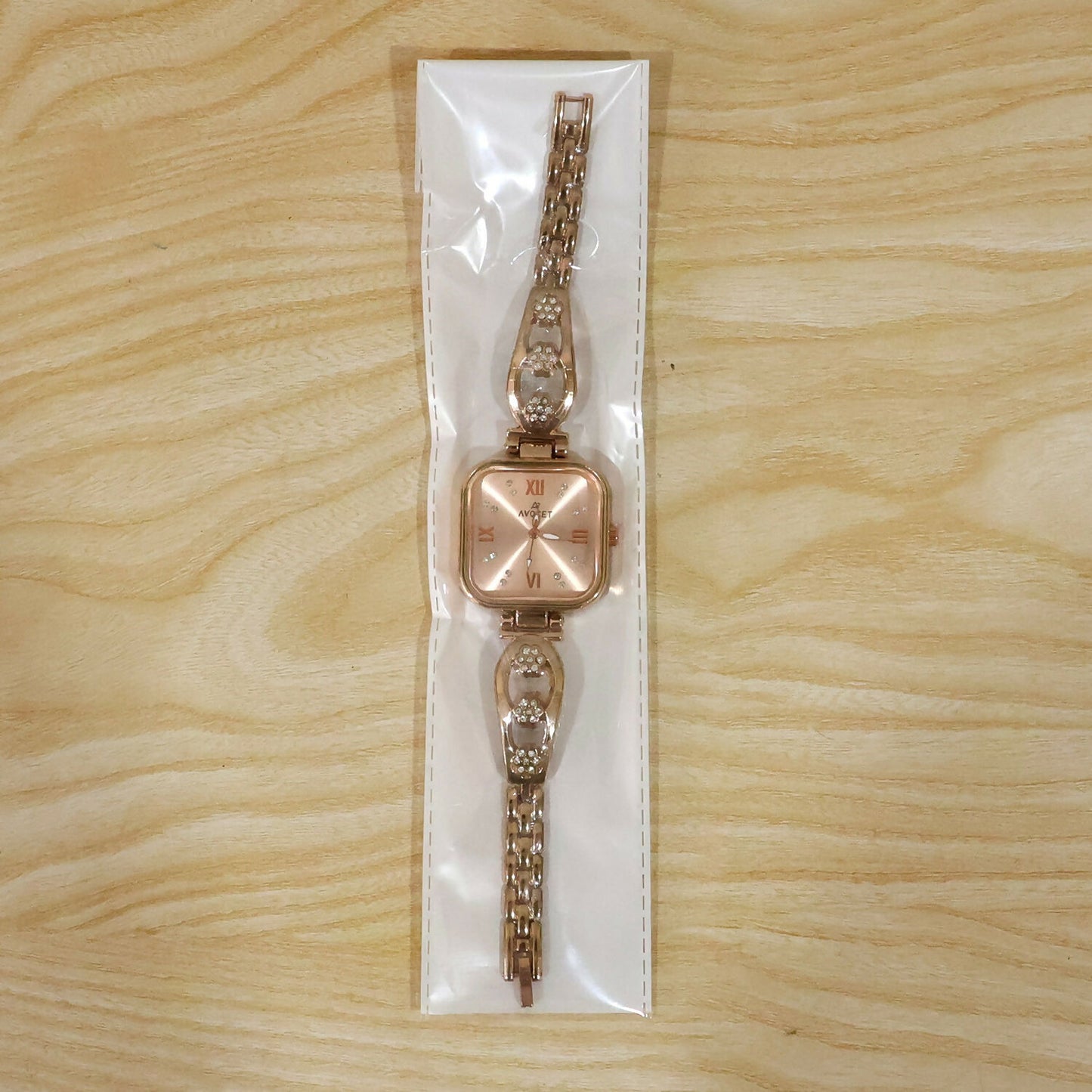 Detailed view of the rose gold watch's clasp and the elegant floral pattern on the strap.
