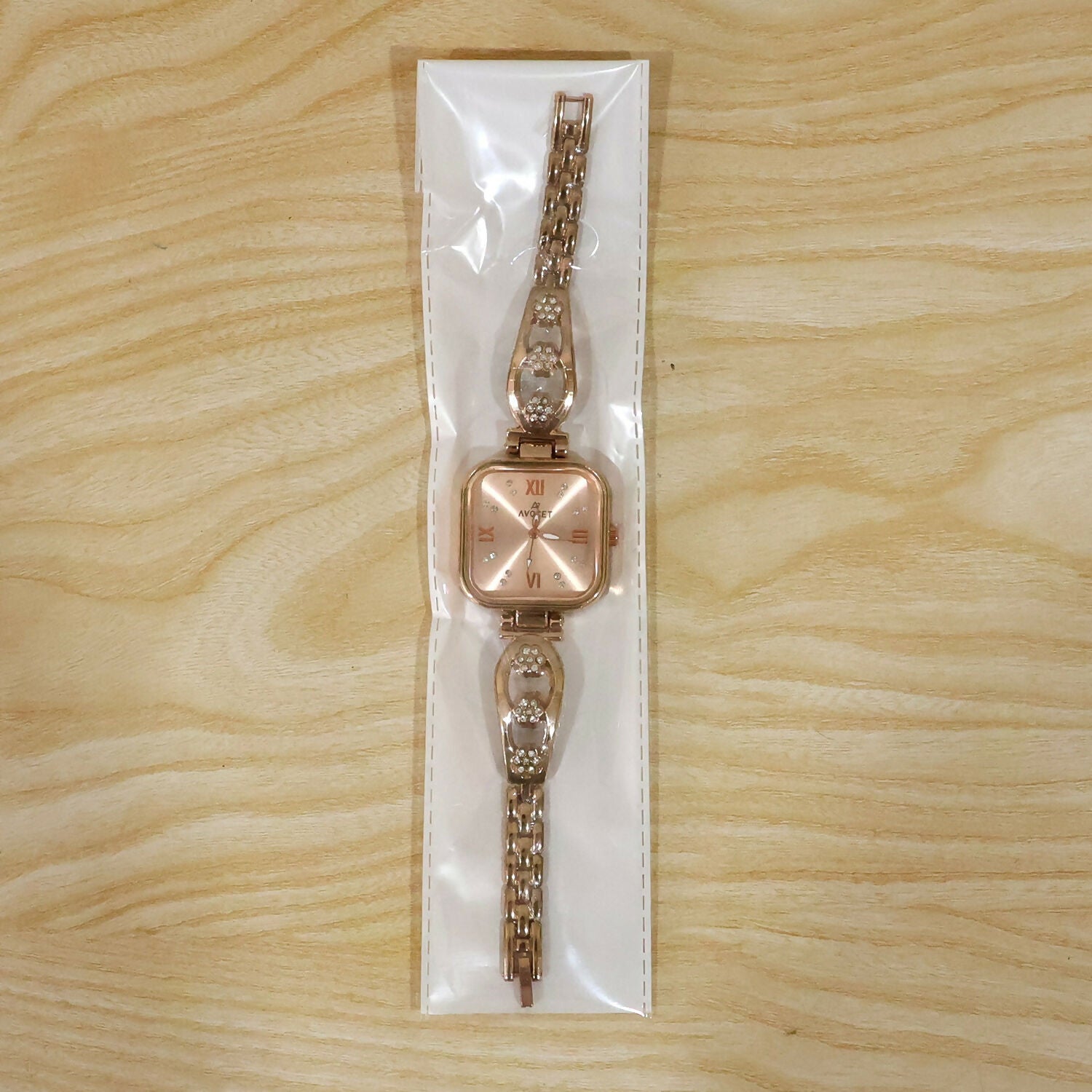 Detailed view of the rose gold watch's clasp and the elegant floral pattern on the strap.