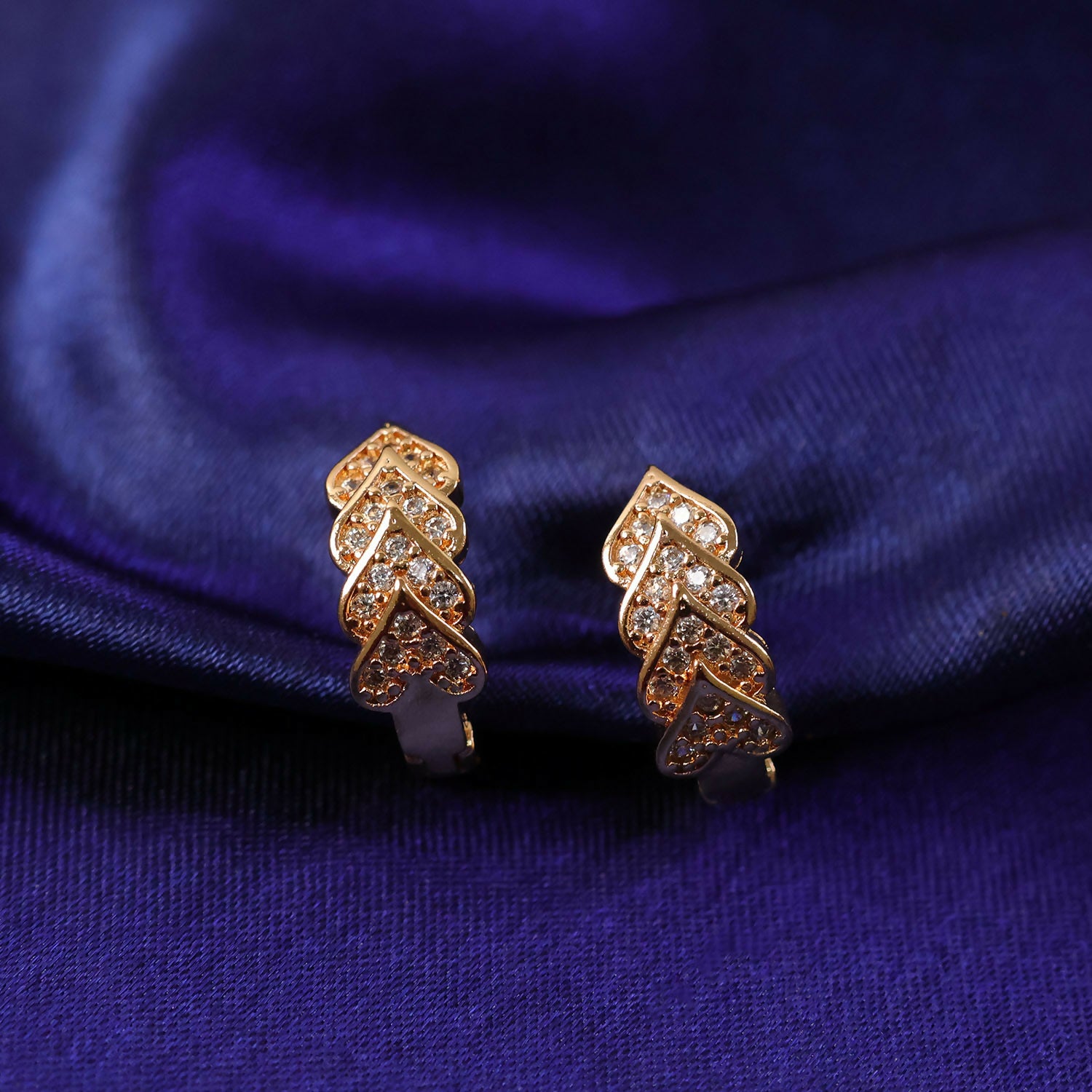 Gold finish leaf pattern stud earrings showcasing detailed craftsmanship and shine