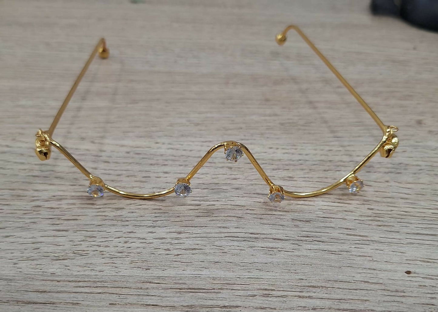 Stylish gold plated zigzag crystal goggles on white background