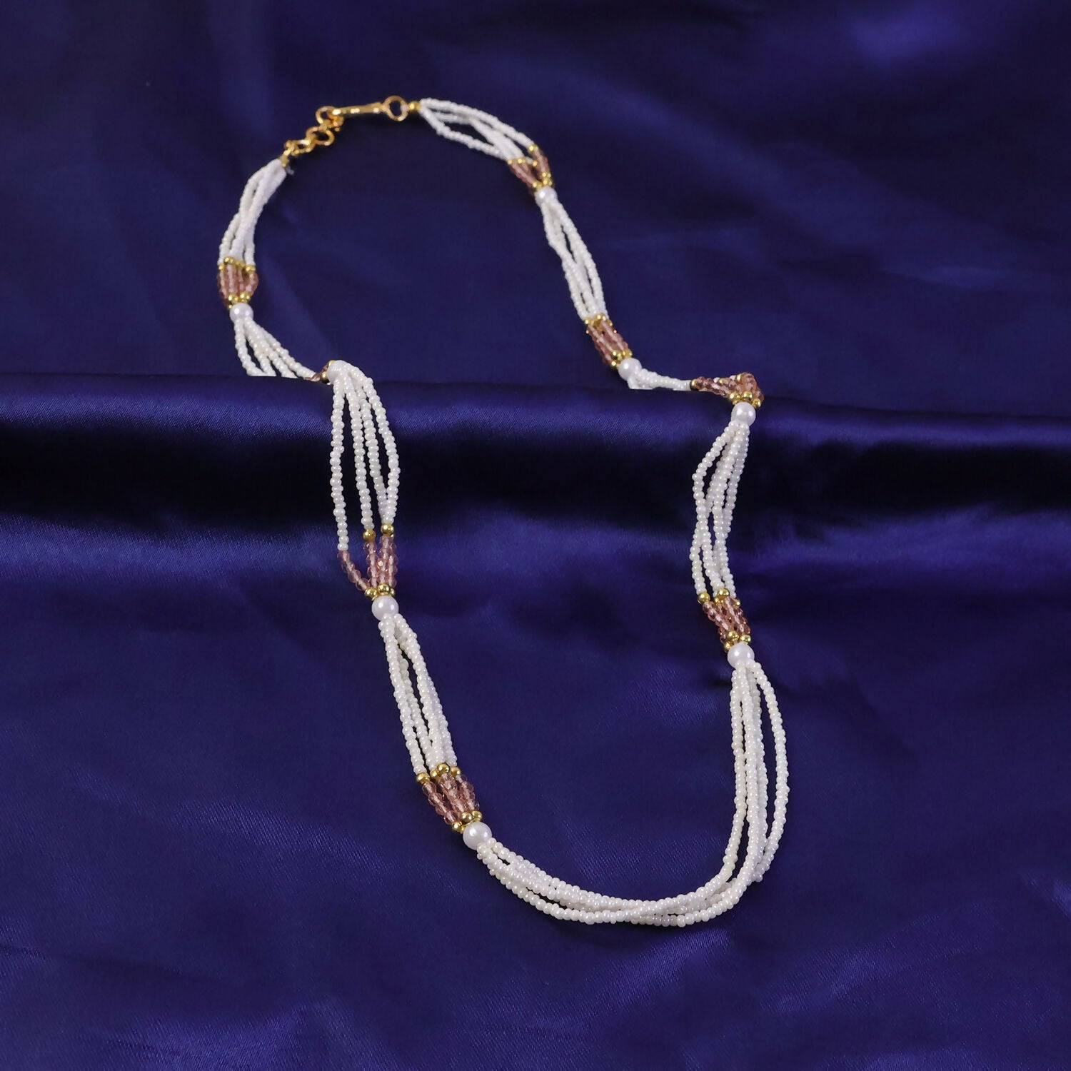 Close-up of pearl and peach beads on ethnic mala necklace