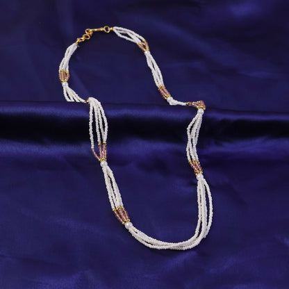 Close-up of pearl and peach beads on ethnic mala necklace