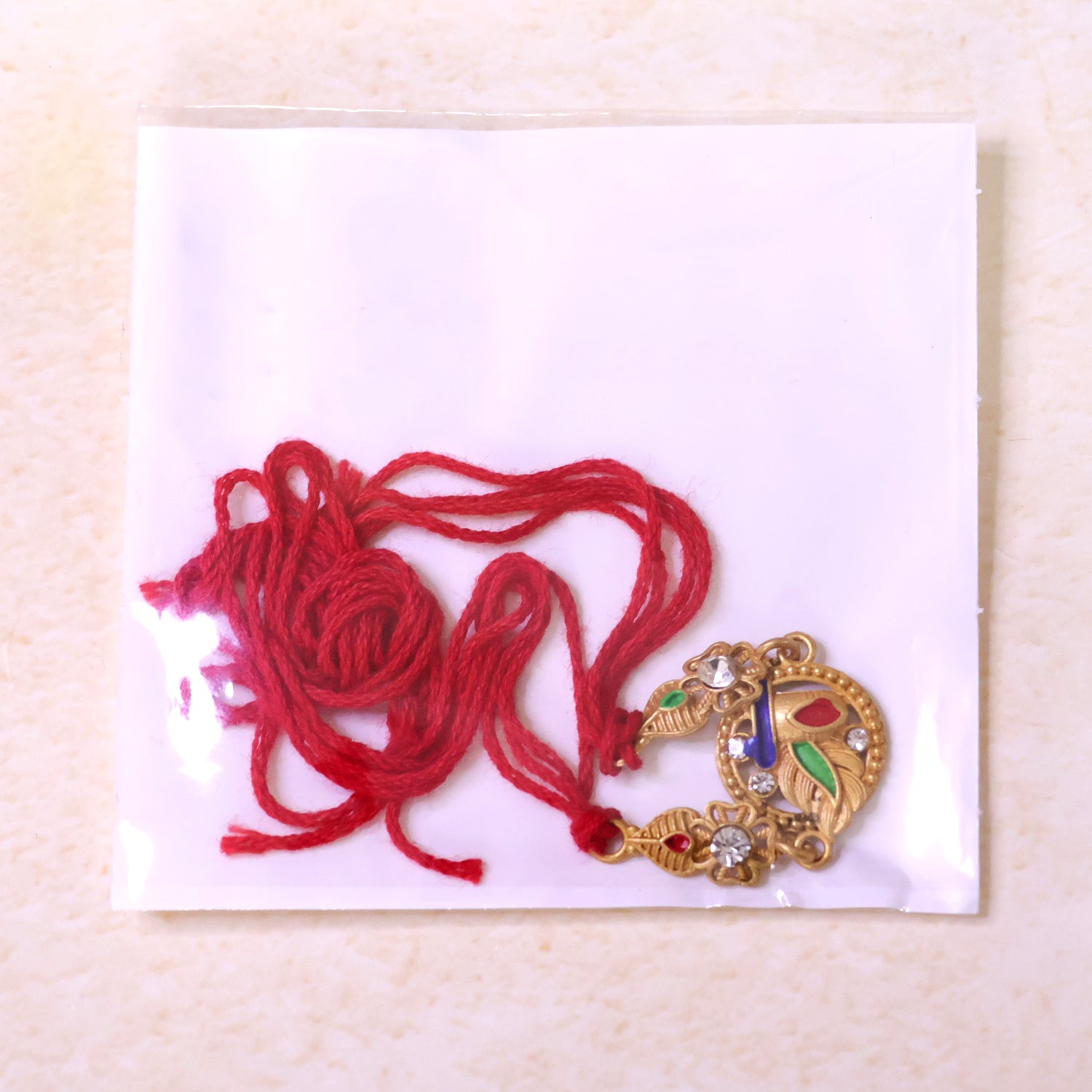 Ornate Rakhi featuring Oval Floral Charm, multicolor stones and chain look for Gift