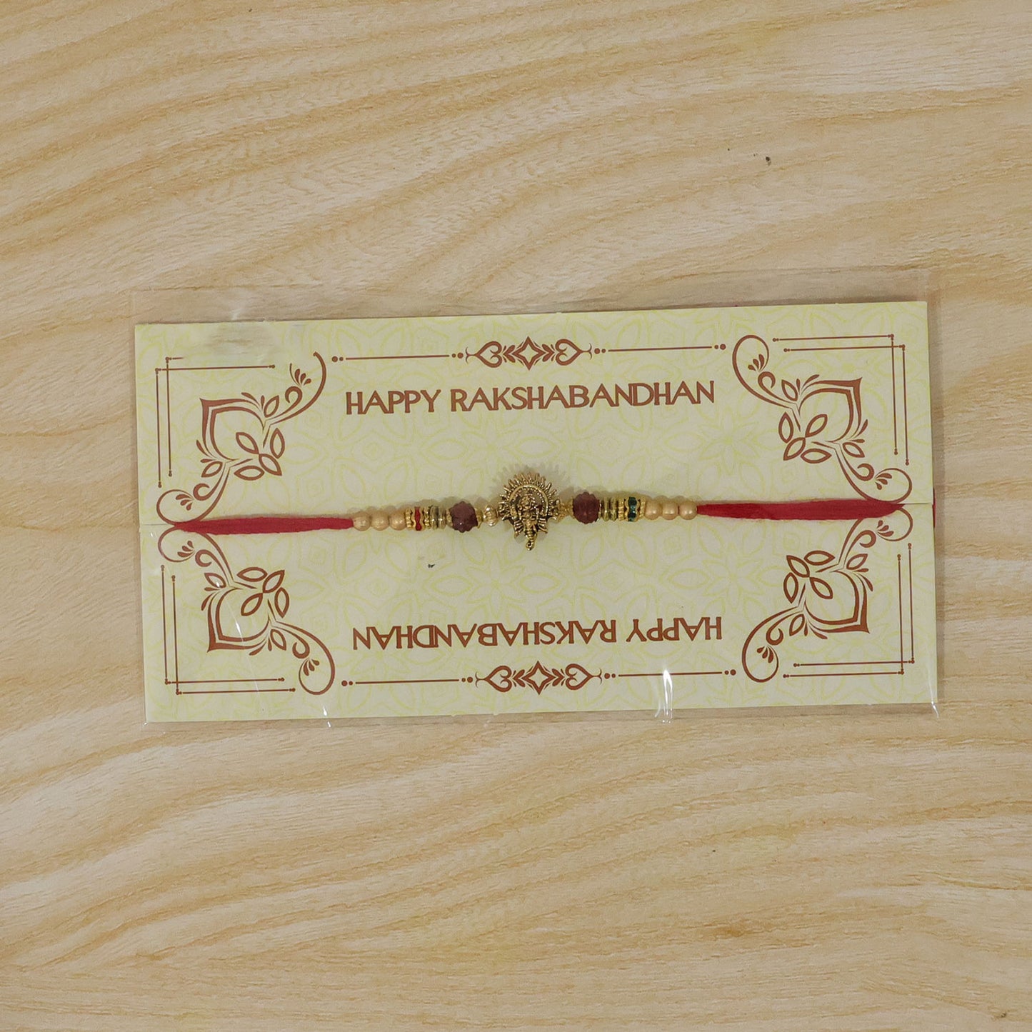 Ganesh Ji Antique Golden Devotional Rakhi with Red Beads and Pearl-Style Accents