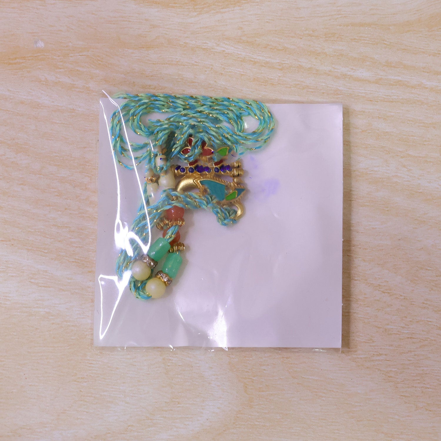 Teal Peacock Enamel Pendant Rakhi with Kundan Flower Accent