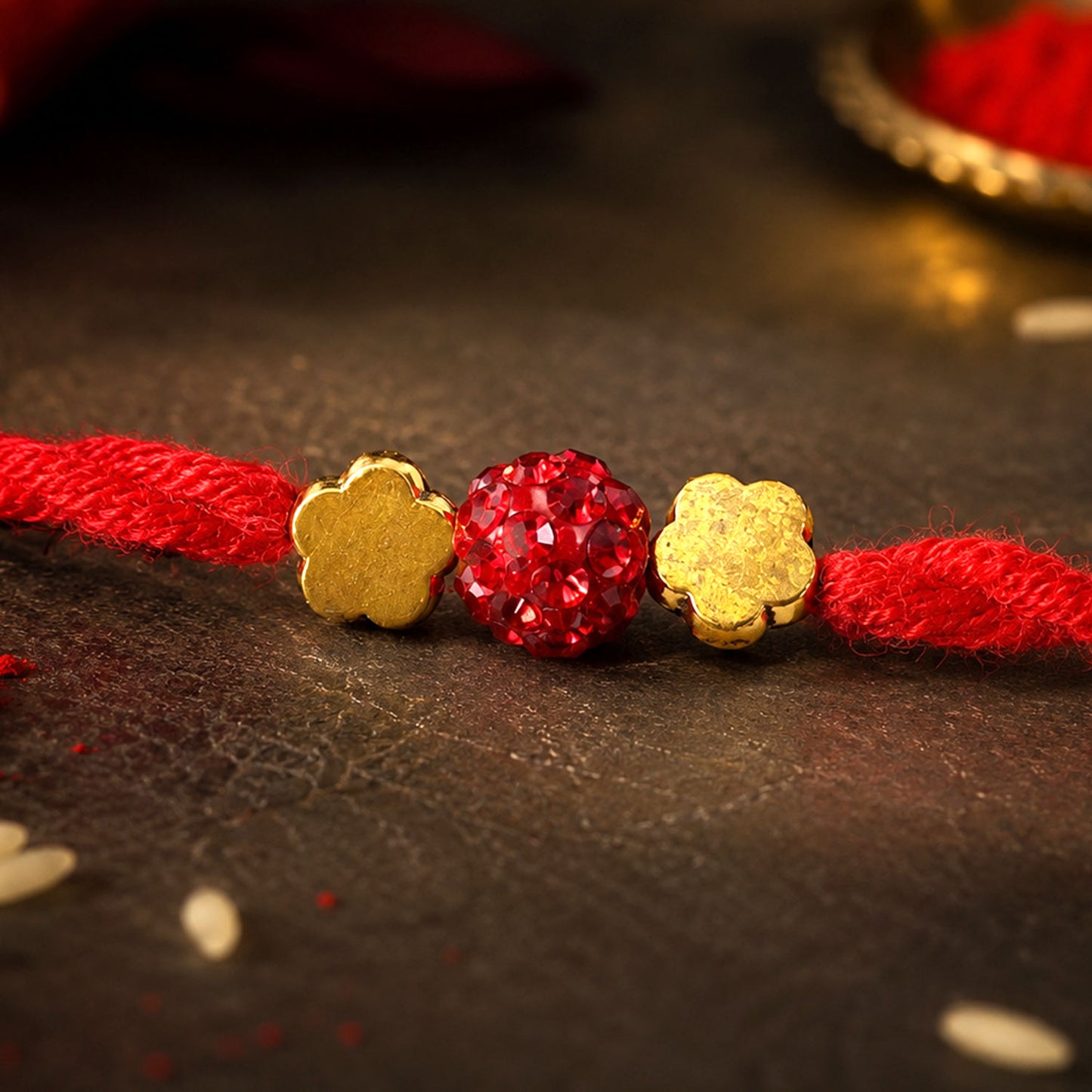 Red Thread Rakhi with Sparkling Red Ball Bead and Gold Flower Accents